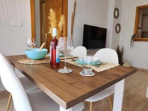 un tavolo in legno con una bottiglia di vino e bicchieri di Salty Apartment Torrevieja a Torrevieja
