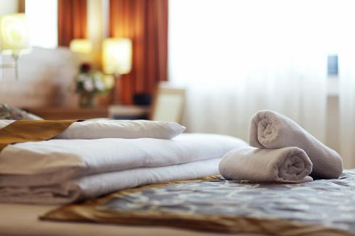a pile of towels sitting on top of a bed at Hotel Kardial in Teslić