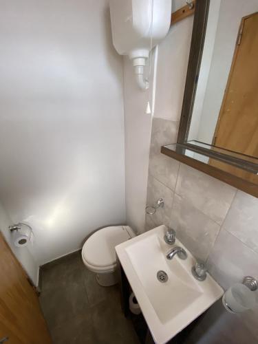 a bathroom with a white toilet and a sink at Casa estilo Americana Bruno - a 15 min del Aeropuerto in Barrio Esteban Echeverría