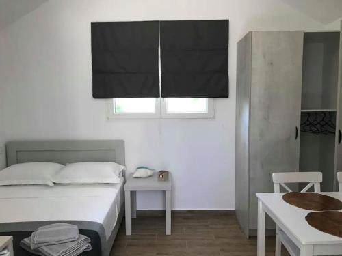 una camera con letto, tavolo e finestra di Calma Kourouta Apartments a Kourouta