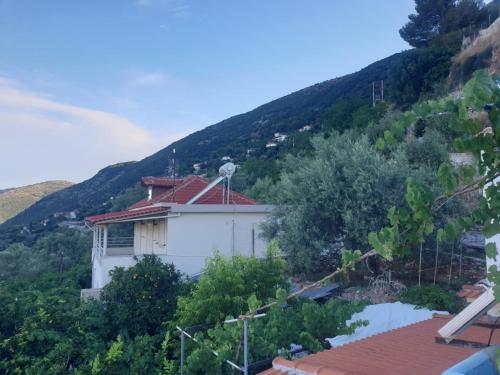 a white building with a mountain in the background at Nice Studio Flat close to Saranda Albania in Nivicë