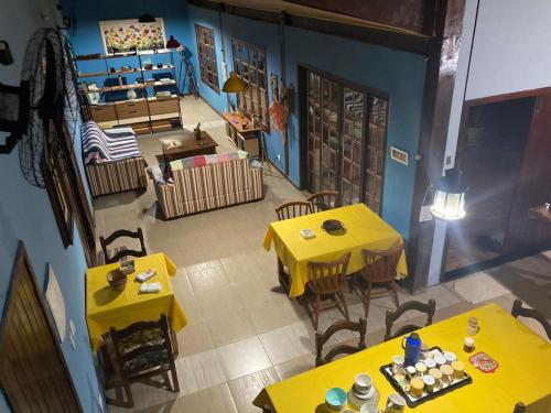 widok na restaurację z żółtymi stołami i krzesłami w obiekcie CASA DA BARRA- Suítes privativas em Saquarema w mieście Saquarema