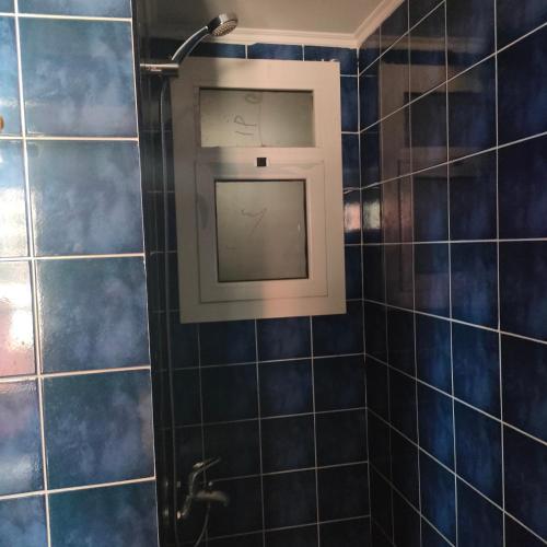 a shower with a window in a bathroom with blue tiles at Flat 11 B, Villa 29, Porto sharm El sheikh in Sharm El Sheikh
