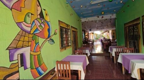 a restaurant with a painting on the wall at Hostal y Restaurante Posada Real in La Palma