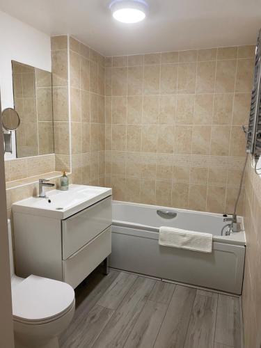 a bathroom with a tub and a toilet and a sink at Marine Viewing 2 bedrooms flat in Manchester