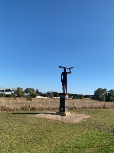 a statue of a man with an umbrella on a field at The Beach House in Middleton