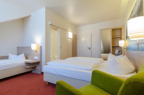 a hotel room with two beds and a couch at Garden Hotel in Nürnberg