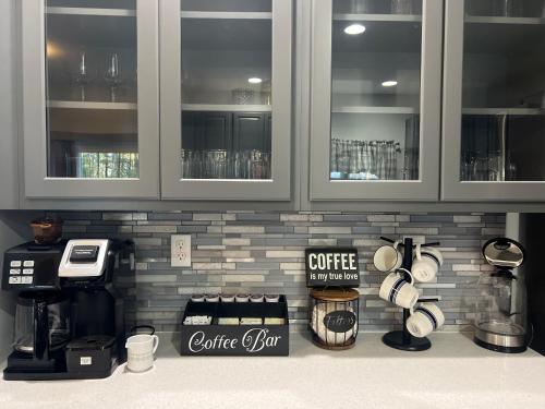 a kitchen counter with a coffeemaker and a coffee station at Luxury Villa- Hot Tub-King Bed Suite-Fenced Yard-Game Room-Fire Pit-Ski in East Stroudsburg