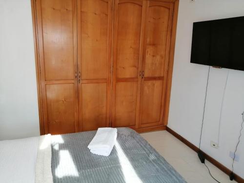 Schlafzimmer mit einem Bett und einem Holzschrank in der Unterkunft Excelente ubicación y acogedor apartamento in Manizales