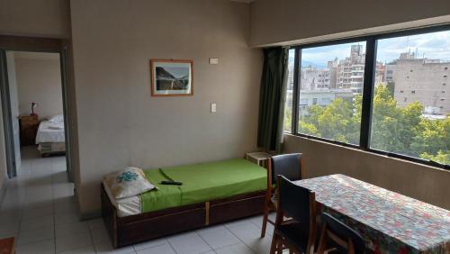 Habitación con cama verde y ventana en Mendoza Deluxe en Mendoza