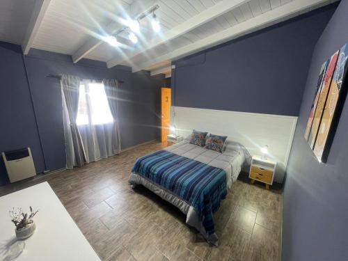 a bedroom with a bed and a blue wall at SOUL B&B in El Calafate