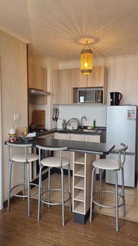 a kitchen with a table and chairs and a refrigerator at Departamento bien ubicado in Concepción