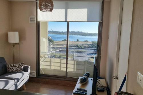 a living room with a large window with a view of the water at Departamento bien ubicado in Concepción