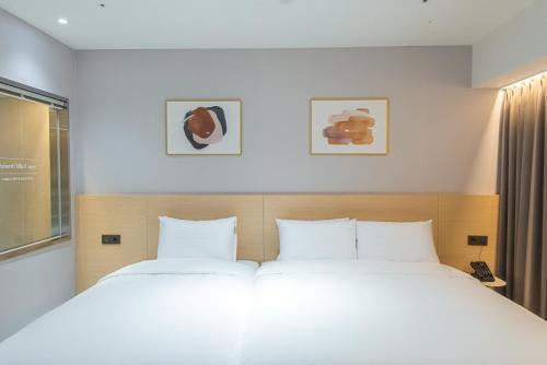 a bedroom with a large bed with two white pillows at Asherah Villa d' aqua Hotel in Gimhae