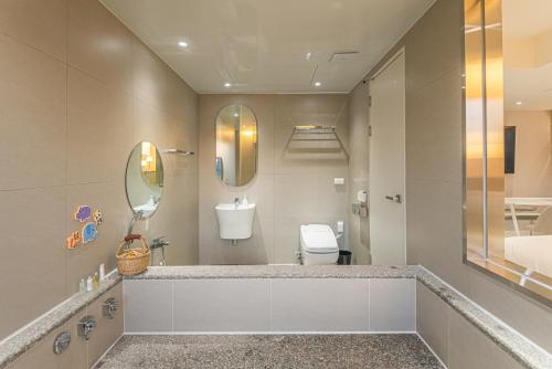 a bathroom with a sink and a toilet and a mirror at Asherah Villa d' aqua Hotel in Gimhae