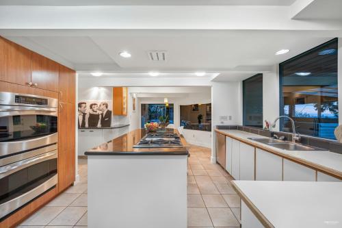 a large kitchen with white cabinets and stainless steel appliances at Seymour Private Bedroom, Ensuite Bathroom with Shared Pool, Hot Tub with Views in North Vancouver