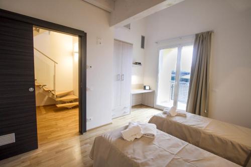 a bedroom with two beds and a large window at Hotel Arezzo ASC in Arezzo