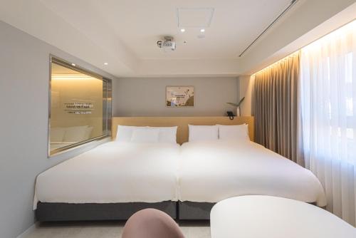 a bedroom with a large white bed and a window at Asherah Villa d' aqua Hotel in Gimhae