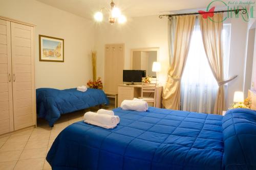 een slaapkamer met twee blauwe bedden en een televisie bij B&B Charme in Sora