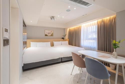 a bedroom with a bed and a table and chairs at Asherah Villa d' aqua Hotel in Gimhae
