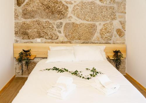 a bed in a room with a stone wall at CASA DO SOL , Turismo Rural in Celorico de Basto