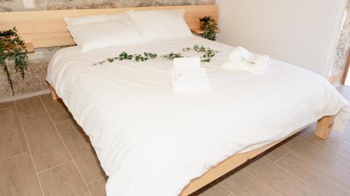 a white bed with flowers on it in a room at CASA DO SOL , Turismo Rural in Celorico de Basto