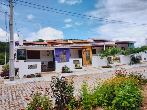 une maison avec des fleurs devant elle dans l'établissement Chalés Recanto das Flores RN, à Monte das Gameleiras