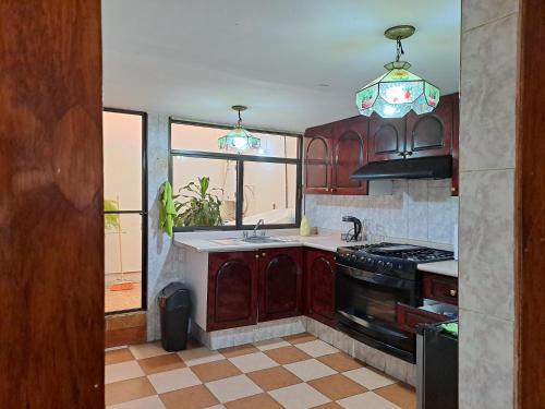a kitchen with wooden cabinets and a stove top oven at 7 camas 1 sofá cama, 20min Airport in Mexico City
