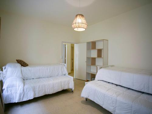 a living room with two beds and a couch at La Casa de la Plaza in San Antonio de Areco