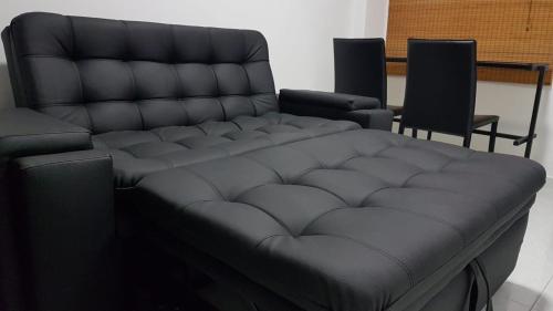 a black couch in a room with two chairs at Coliving Cali in Cali