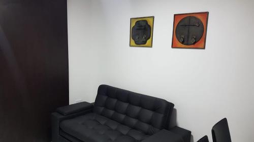 a living room with a couch and two clocks at Coliving Cali in Cali