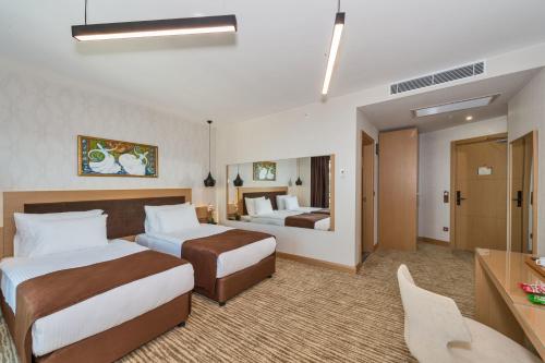 Habitación de hotel con 2 camas y escritorio en Hotel Boursier 1 & Spa, en Estambul