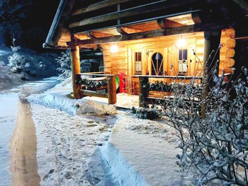 a log cabin in the snow at night at Leśniówka Domki W Karpaczu in Karpacz