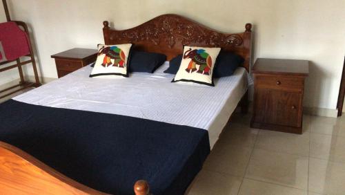 a bedroom with a large bed with two pillows at Tranquil Private Villa near Bentota Beach in Bentota