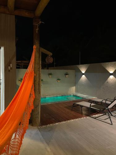 an orange hammock on the side of a swimming pool at MAKAI Milagres in São Miguel dos Milagres