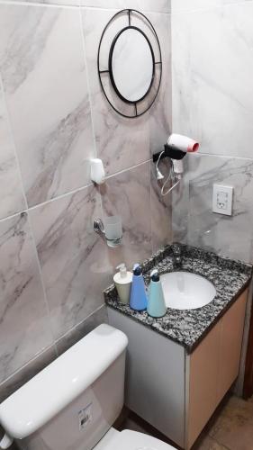 uma casa de banho com um lavatório, um WC e um espelho. em VB Home em Posadas