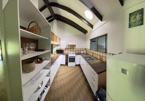 a large kitchen with white cabinets and a green refrigerator at Botanica House Kuranda in Kuranda