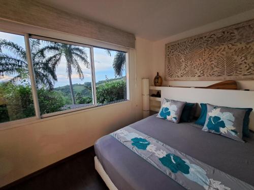 ein Schlafzimmer mit einem Bett und einem großen Fenster in der Unterkunft PACIFIC VIEW Homestay in Punaauia