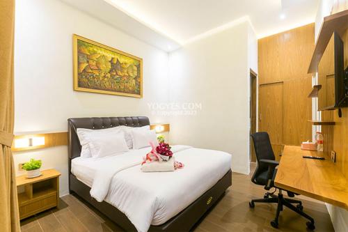 a hotel room with a bed and a desk and a desk at KESATRIYAN JOGJA GUEST HOUSE in Yogyakarta