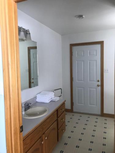 a bathroom with a sink and a mirror at Lakeside Luxury 4 bedrooms 2 bath sleeps 10 with Gazebo and Firepit in Presque Isle