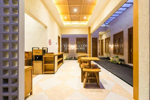 a cafeteria with tables and chairs in a building at KESATRIYAN JOGJA GUEST HOUSE in Yogyakarta