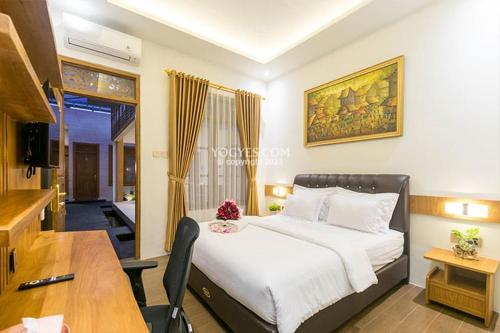 1 dormitorio con cama, mesa y escritorio en KESATRIYAN JOGJA GUEST HOUSE, en Yogyakarta