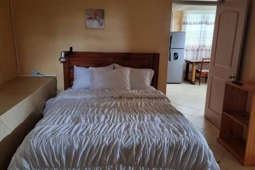 a bedroom with a large bed with white sheets at Arliebev Apartments in Mahaut