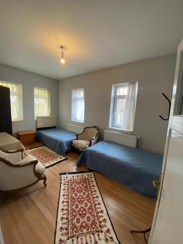 a bedroom with two beds and a chair and a couch at Acan Apart günlük kiralık ev Ürgüp in Ürgüp
