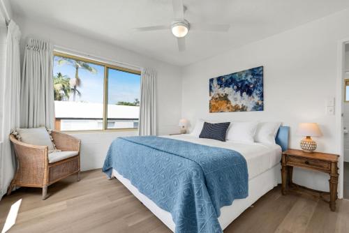 a white bedroom with a bed and a window at Surf Dance Apartments in Coolum Beach