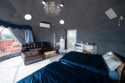 a bedroom with a bed and a couch at HIKARI DOME - Vacation STAY 49575v in Teruma