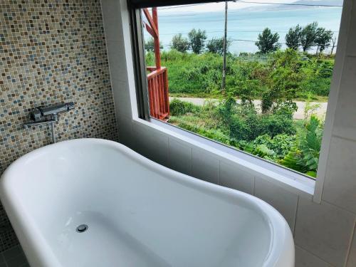 a white bath tub in a bathroom with a window at HIKARI DOME - Vacation STAY 49575v in Teruma
