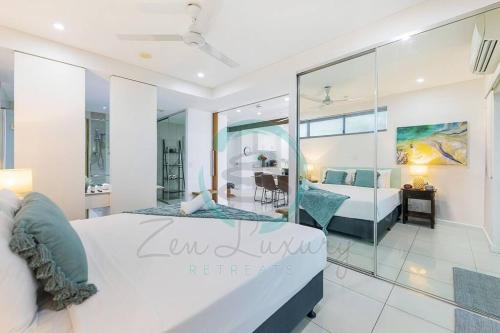 a bedroom with a large bed and a living room at ZEN Crown Towers 3-BR Luxury Pad in Darwin