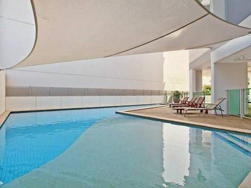 una piscina con acqua blu in un edificio di ZEN Crown Towers 3-BR Luxury Pad a Darwin