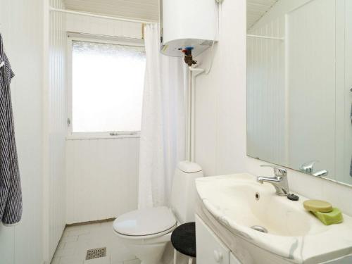 Baño blanco con aseo y lavamanos en Holiday home Melby IV, en Melby